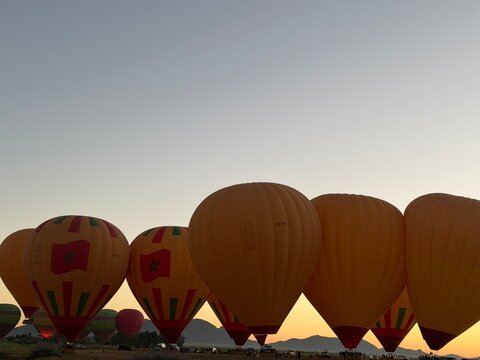 Hot air balloons inflating at sunrise near Marrakesh