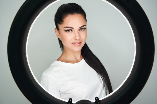 Portrait of young beautiful woman with ring flash. Round LED Circle Lamp in studio