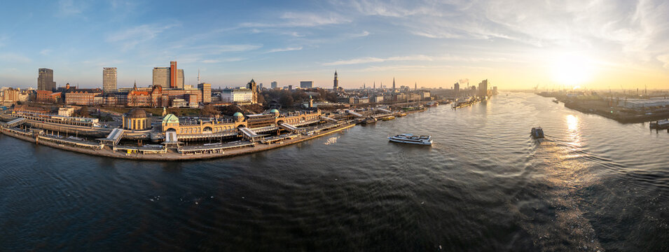 Aerial view of Landungsbrucken and the Elbe river at sunrise with boats and the city skyline in Hamburg, Hamburg, Germany.