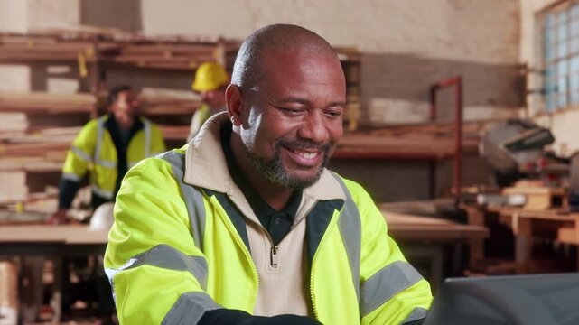 Carpenter, man and smile in workshop with laptop, good news and email for woodwork procurement offer. Mature person, carpentry manager and happy with computer, reading online order or production deal