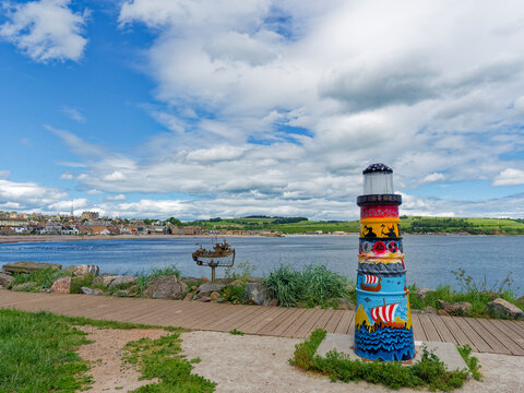 Part of Stonehaven Sculpture Trail with a gaily painted model Lighthouse and metal sculpture of a Fishing Boat next to the Boardwalk.