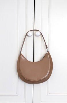 Here are two descriptions and a set of 50 SEO-optimized keywords for the brown crescent-shaped handbag shown in your final image.