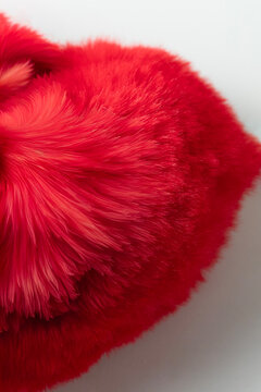 close-up and abstract shot of a bright red, fluffy fabric or fur. The image highlights the soft, wispy texture of the material, with individual strands visible and a light color variation.