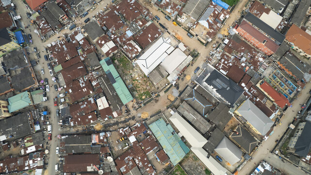 Aerial view of dense urban neighborhood with corrugated metal rooftops, narrow streets, and residential buildings in Lagos, Lagos, Nigeria.