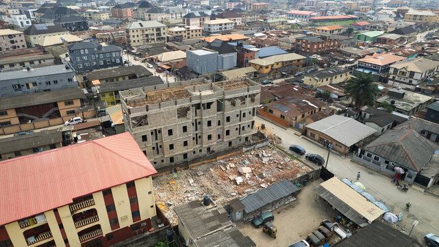 Aerial view of a construction site with a multi-story building under development surrounded by dense urban residential housing and streets in Lagos, Lagos, Nigeria.