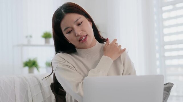 Asian woman using laptop for video conference with doctor at home, telemedicine