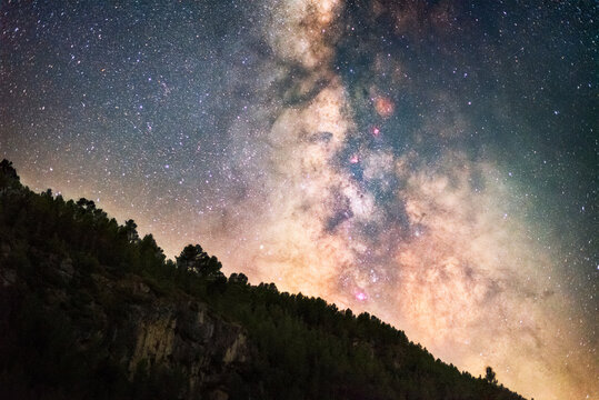 Astrophotography of Milky Way starry sky above dramatic rocky mountain