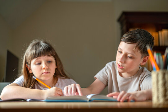 Brother and sister completing homework together at home