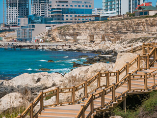 Fototapeta premium Scenic cliffside stairs on Aktau rock trail, Kazakhstan. Coastal boardwalk path near Caspian Sea, epic geological limestone formations