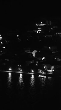 Pag Night city at sea panning over with lights shining in water
