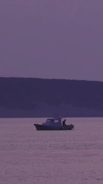 Lonesome fishing boat on sea after sunset