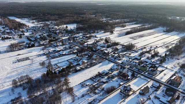Snow covered suburb roofs showing home insulation differences
