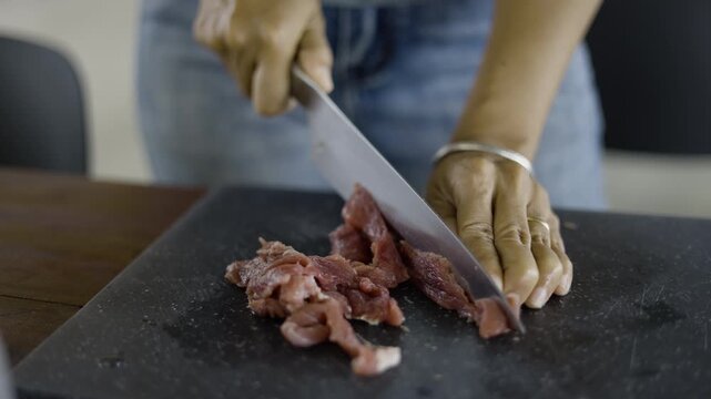 Chef Carefully Slicing Fresh Raw Beef On A Cutting Board
