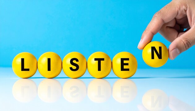 Yellow spheres spell listen with hand lifting final letter