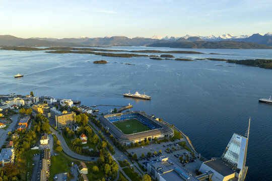Aerial view of Aker Stadium on the waterfront, featuring the green pitch and surrounding urban landscape along the Romsdalsfjord in Molde, More og Romsdal, Norway.