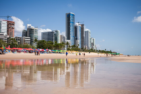 Boa Viagem beach with the city skyline reflected on wet sand, Recife, Pernambuco, Brazil