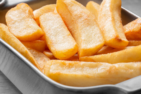 Tripled cooked fried chips in a stoneware dish. Traditional British fried food concept. Edited with selective colour