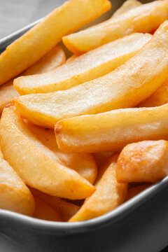 Tripled cooked fried chips in a stoneware dish. Traditional British fried food concept. Edited with selective colour