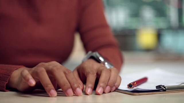 Close-up image of a woman clasping her hands in a tense posture, reflecting self-doubt, insecurity, and lack of confidence. Ideal for illustrating emotional struggle, anxiety, stress, and mental well-