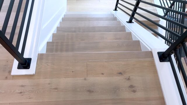 Wooden staircase with black railings perspective interior view