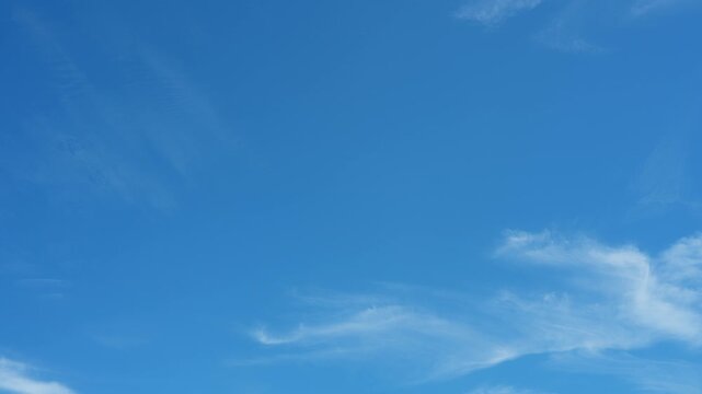 A blue sky timelapse video featuring delicate cirrus and thin cirrostratus clouds floating like sky ribbons, evoking clean air, open space, dream travel, mindful calm, peaceful atmospheric motion. 4k.