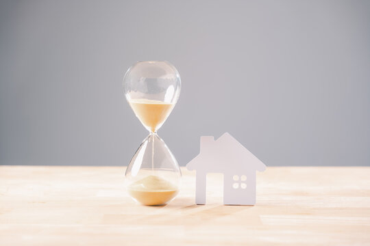 Hourglass time house home money mortgage concept, sand flowing, real estate investment, loan, property, building, buying, selling, accommodation, temporary