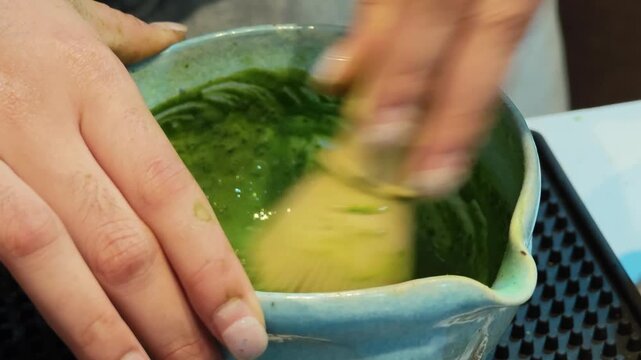Stirring a pure matcha drink at a coffee shop.	