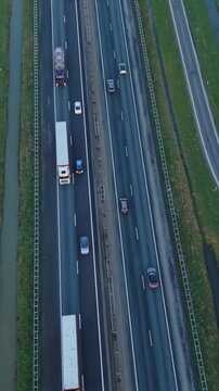 Vertical screen Cargo Route Overview. Highway Corridor Featuring Freight And Passenger Vehicles. Aerial Perspective Showing Freight And Personal Vehicles Traveling Along Divided Highway