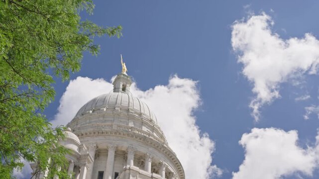 Cinematic tilt down from the marble dome of the Rhode Island State House to the Oliver Hazard Perry Monument in downtown Providence on a sunny summer day.