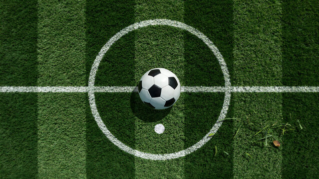 Soccer ball resting on the center circle of a green artificial grass sports
