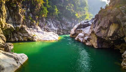 Obraz premium Serene emerald river winding through rocky canyon with lush forest.