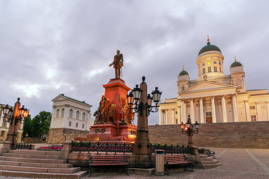 Monument to Russian Emperor Alexander II with illuminated neoclassical Helsinki Cathedral on the background on Senate square in Helsinki, Finland