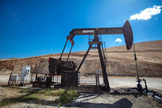 Oil Pumpjack in Dry Rural Landscape Under Blue Sky &ndash; Petroleum Extraction and Fossil Energy Industry Concept