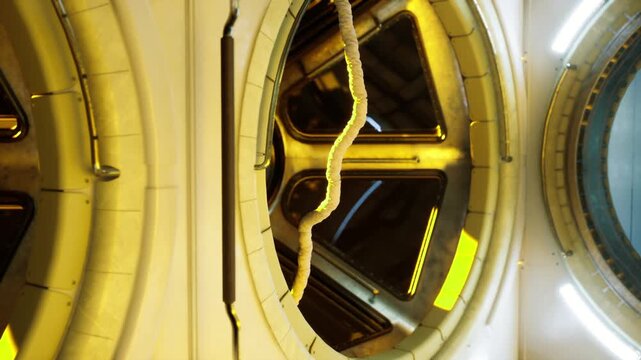 Training hatch corridor inside space station, microgravity simulator impressions, harness and tether zones, ambient yellow lighting, exercise and safety role