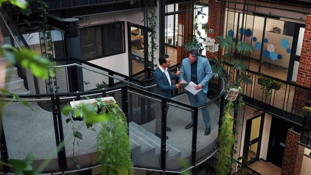 People, talk and tablet in office with sustainable business, planning and online research from above. Team, tech and discussion on stairs for eco friendly goals, environmentalist advice and strategy.