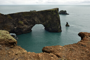 Fototapeta premium Massive stone arch of Dyrholaey peninsula rising from the sea, Iceland