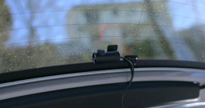 Close-up of black 70mai A810S dash camera device attached to glass of rear car window