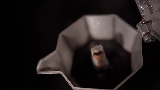 Overhead close-up of espresso rising inside moka pot during brewing process. Concept of traditional coffee ritual and cozy morning lifestyle.