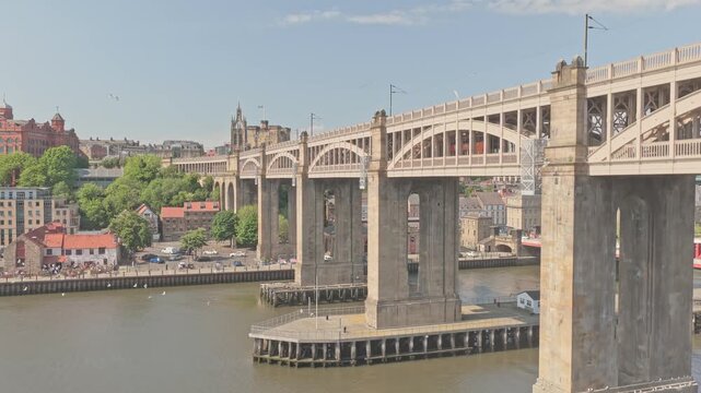 High Level Bridge spans the River Tyne between Newcastle upon Tyne and Gateshead, showcasing Victorian railway engineering and historic infrastructure, drone ascent shot.