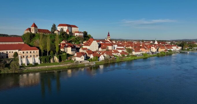 Aerial pan left of Ptuj Castle, red rooftops in Ptuj old town and the Drava River, Slovenia.