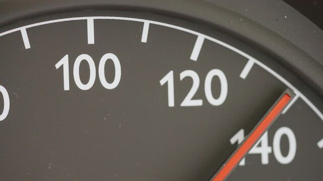 Macro shot of an analog car speedometer needle pointing at exactly 130 kmh, conceptualizing the discussed German Autobahn speed limit debate and climate policy