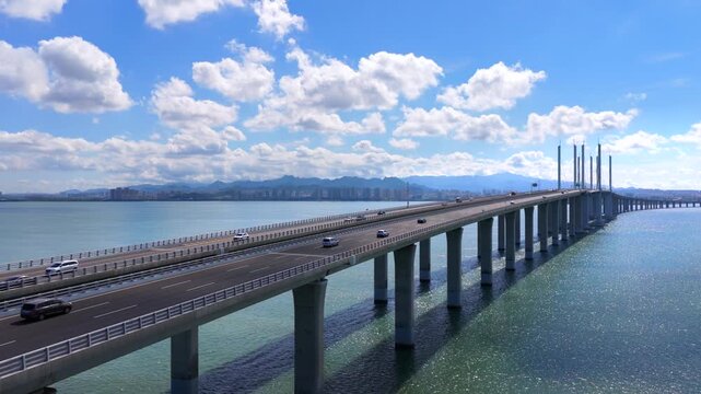 Coastal highway bridge spanning Jiaozhou Bay, Qingdao urban transportation landscape under cloudy sky