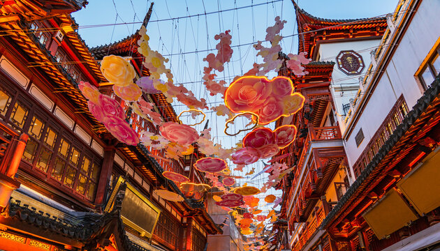 City scape of traditional chinese architecture building with carved roofs and hanging decorations in Yu Garden old street in shanghai as famous travel destination for summer vacations in evening