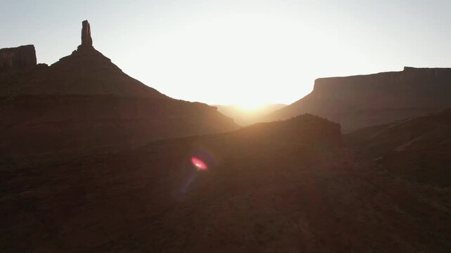 Drone flying sideways filming the sunrise at Castleton Tower in Moab in 4k