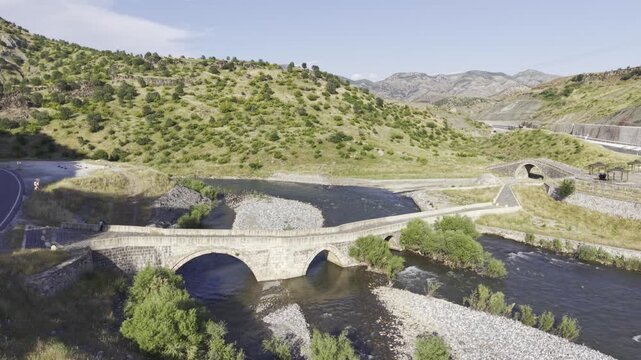 Cinematic View of Historic Kasrik Bridge in Siirt, Turkiye &ndash; Stone Arch Bridge Over Botan River and Anatolian Heritage