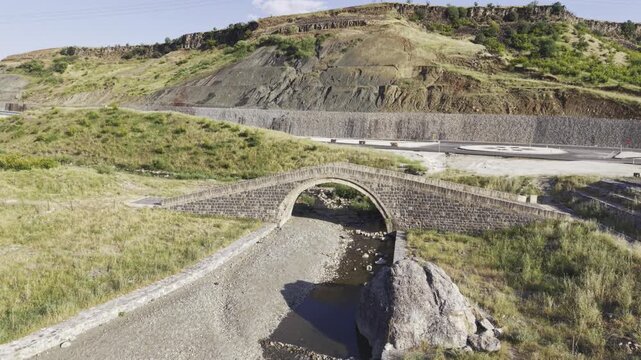 Cinematic View of Historic Kasrik Bridge in Siirt, Turkiye &ndash; Stone Arch Bridge Over Botan River and Anatolian Heritage