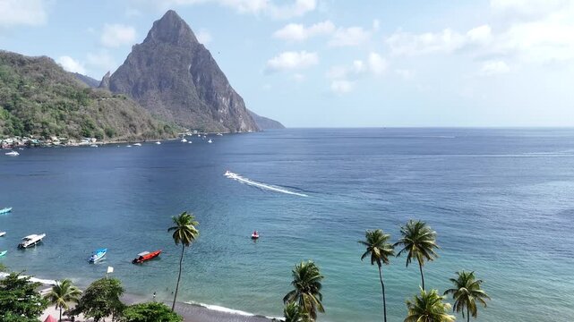 Aerial drone shot of the iconic Pitons mountains rising from the sea with palm trees in Saint Lucia, Caribbean