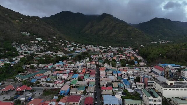 drone overview of colorful hillside residential houses in Soufriere town surrounded by dense tropical forest, Saint Lucia