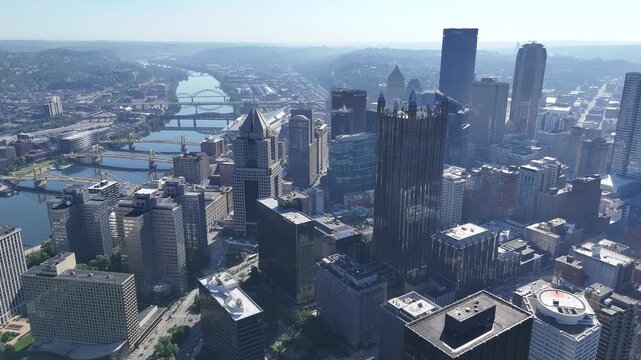 Wide high-altitude drone flight showcasing the dense downtown Pittsburgh skyline and urban river junctions on a clear day, Pennsylvania smart city USA