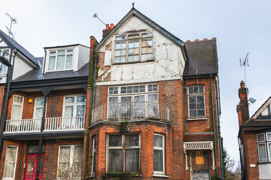 Exterior of an abandoned terrace house, boarded up and neglected in Hornsey, London, UK